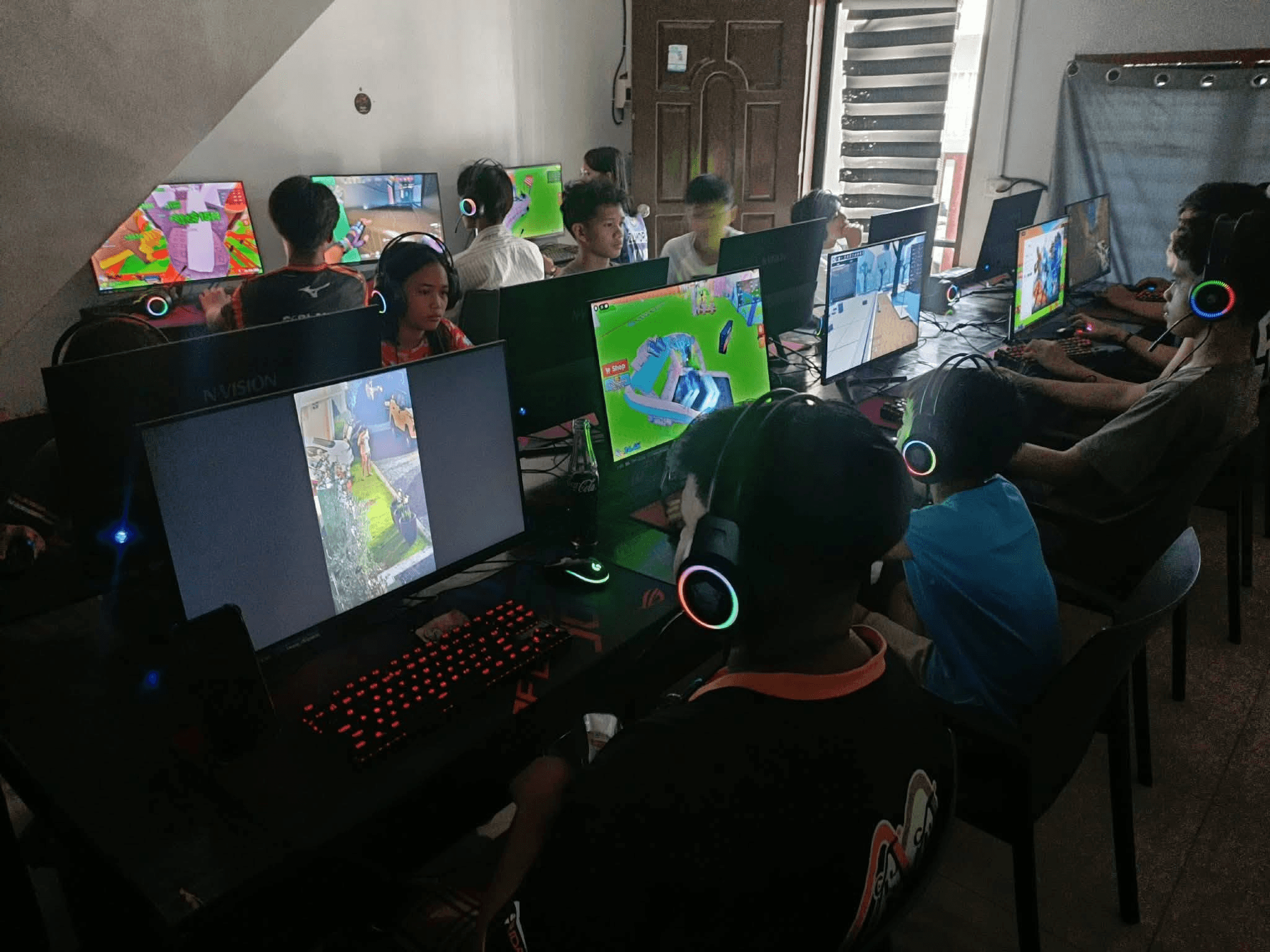 Busy internet cafe room with customers using PC stations managed by CafeCentro